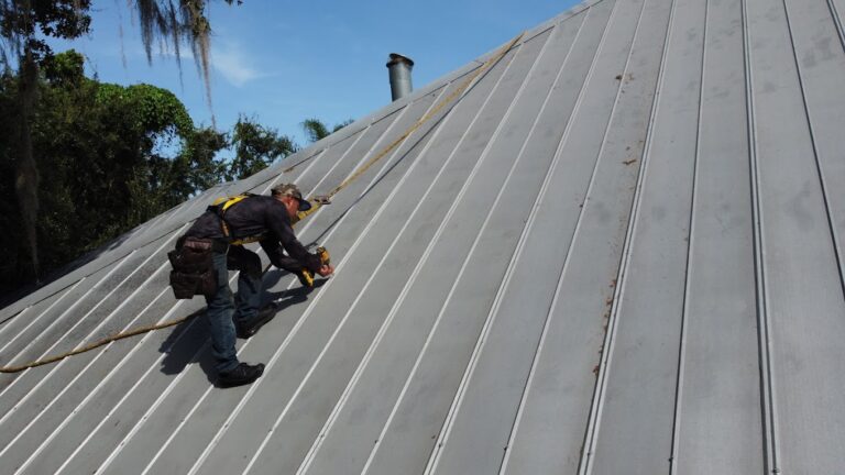 Roofer installing metal roof on home
