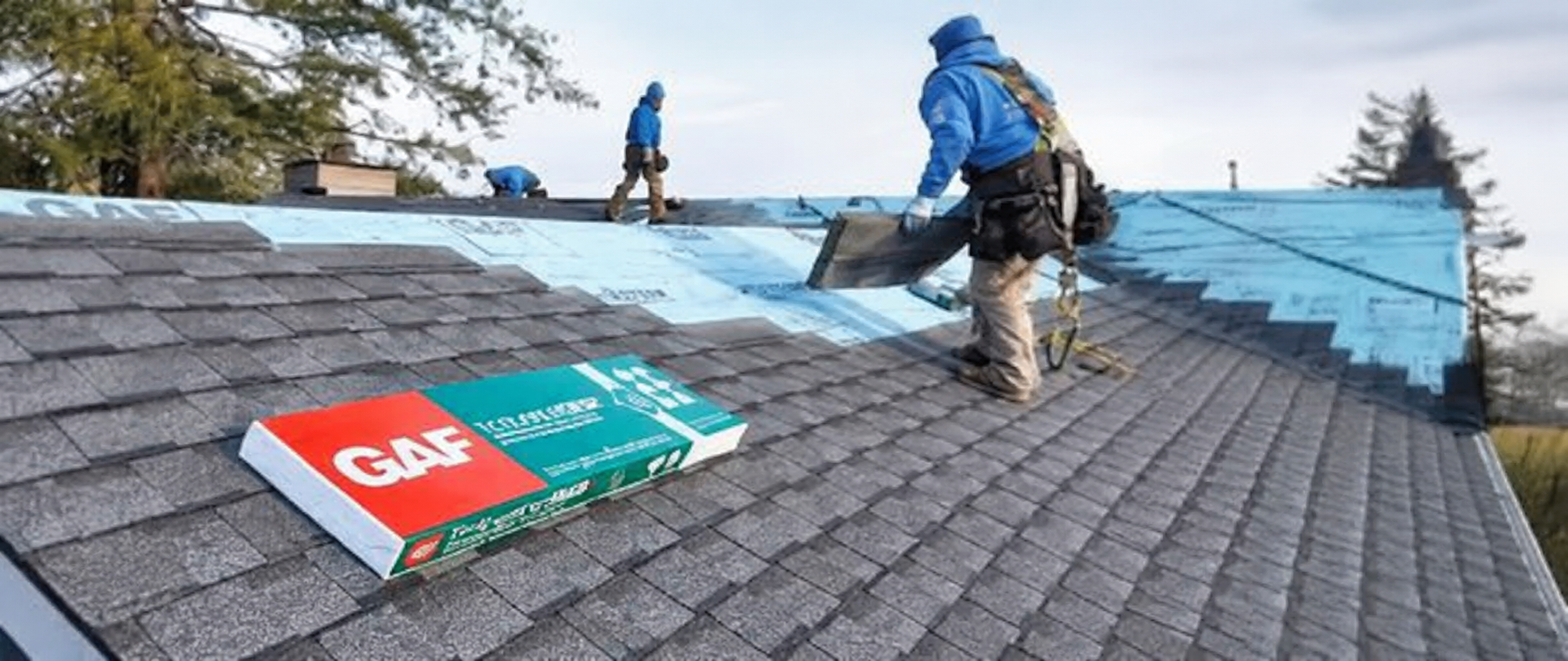 Crew installing new shingles on a roof